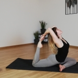 Yogatrainierin mianamaste im Yoga Kurs.