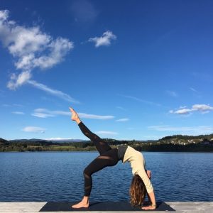Yogatrainerin MiaNamaste im Rad am Steg am Längsee unter blauem Himmel.